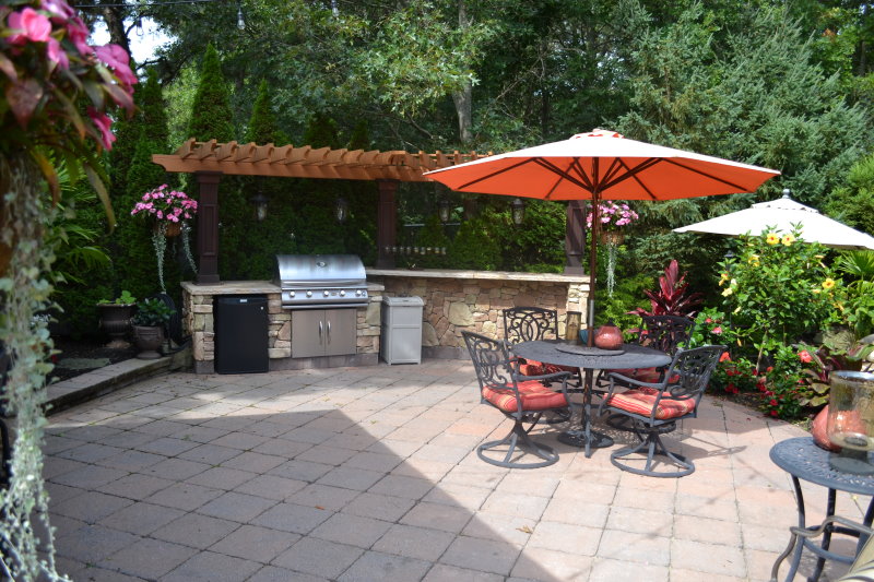 outdoor kitchen island with pergola and lights